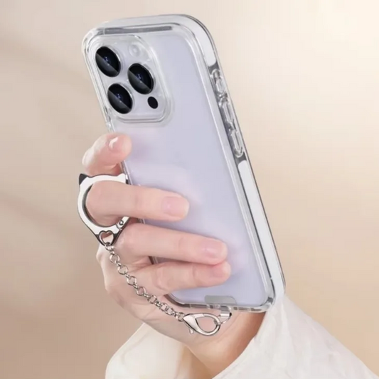 Person holding a phone with a clear case and cat chain accessory against a beige background