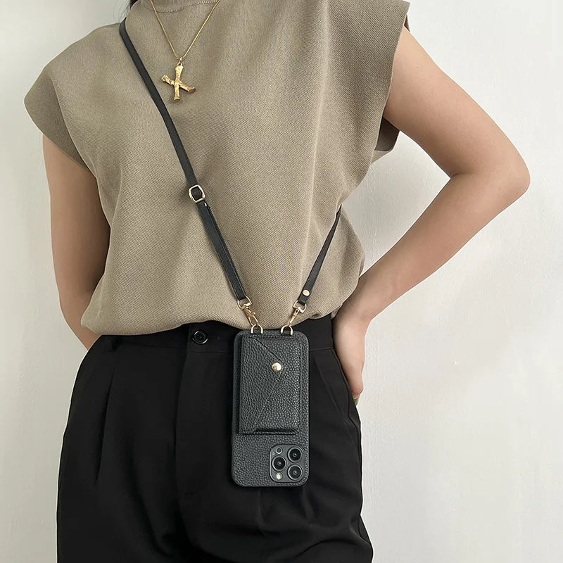 Person wearing a black leather phone case with strap against a light background
