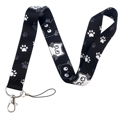 Black lanyard with white cat illustrations and paw prints on a white background