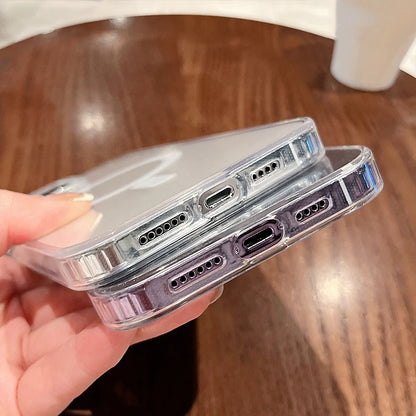Two clear phone cases held by a hand over a wooden surface, showing the bottom of the case where the charging port connects.