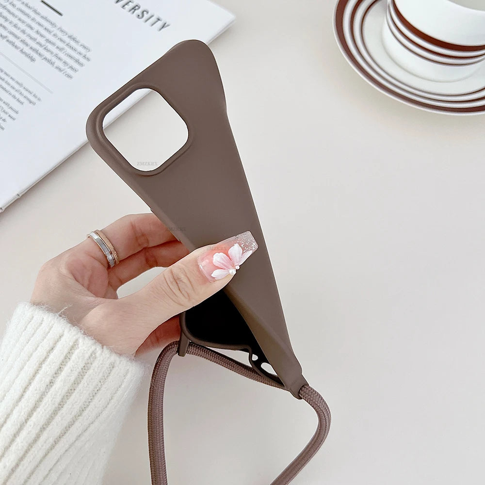Brown phone case with strap held by a hand on a light surface
