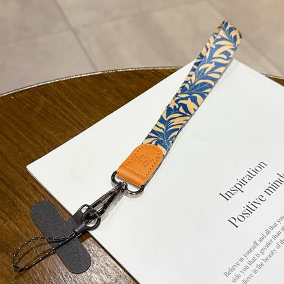 Lanyard with blue leaf pattern and orange accent on a book