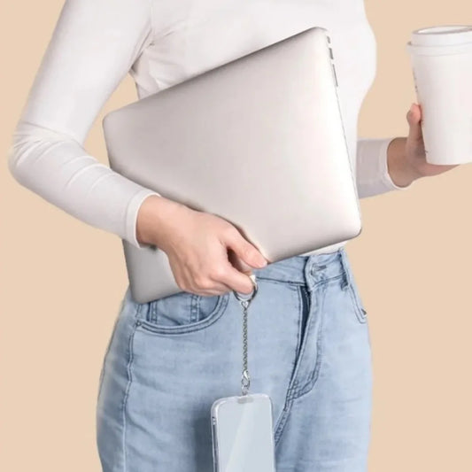 Person demonstrating the use of a cat phone chain tether by using the tether to hold the phone by one finger while their hands are busy holding a laptop and coffee