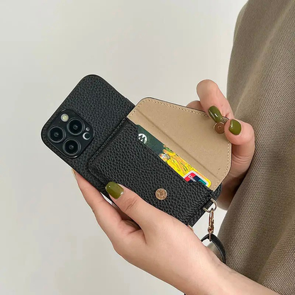 A person holding a black leather phone case with strap demonstrating how the card wallet feature of the case works.