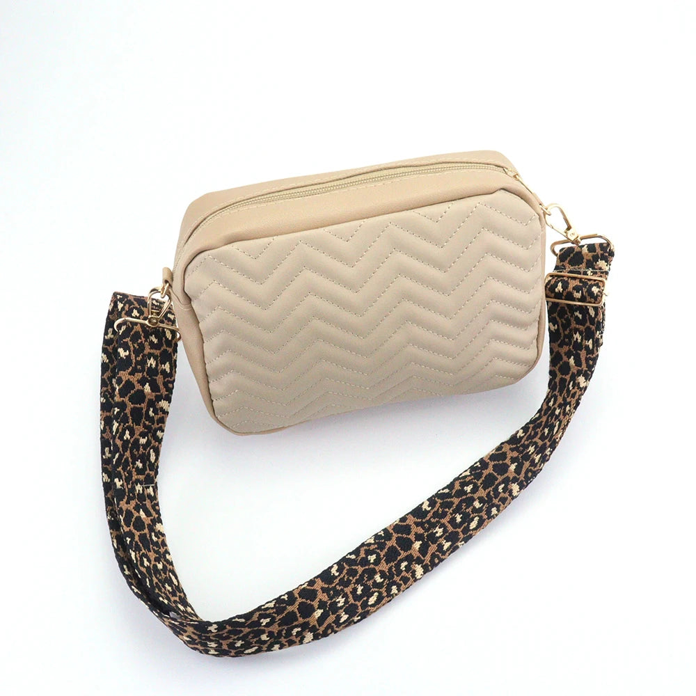 Beige quilted handbag with a leopard print strap on a white background